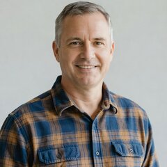 Portrait of a friendly middle-aged man with short grey hair in a casual flannel shirt. He is a satisfied Stump Services Near Me customer in the Portland metro. He had a tree stump ground out of his backyard and the area left clean.